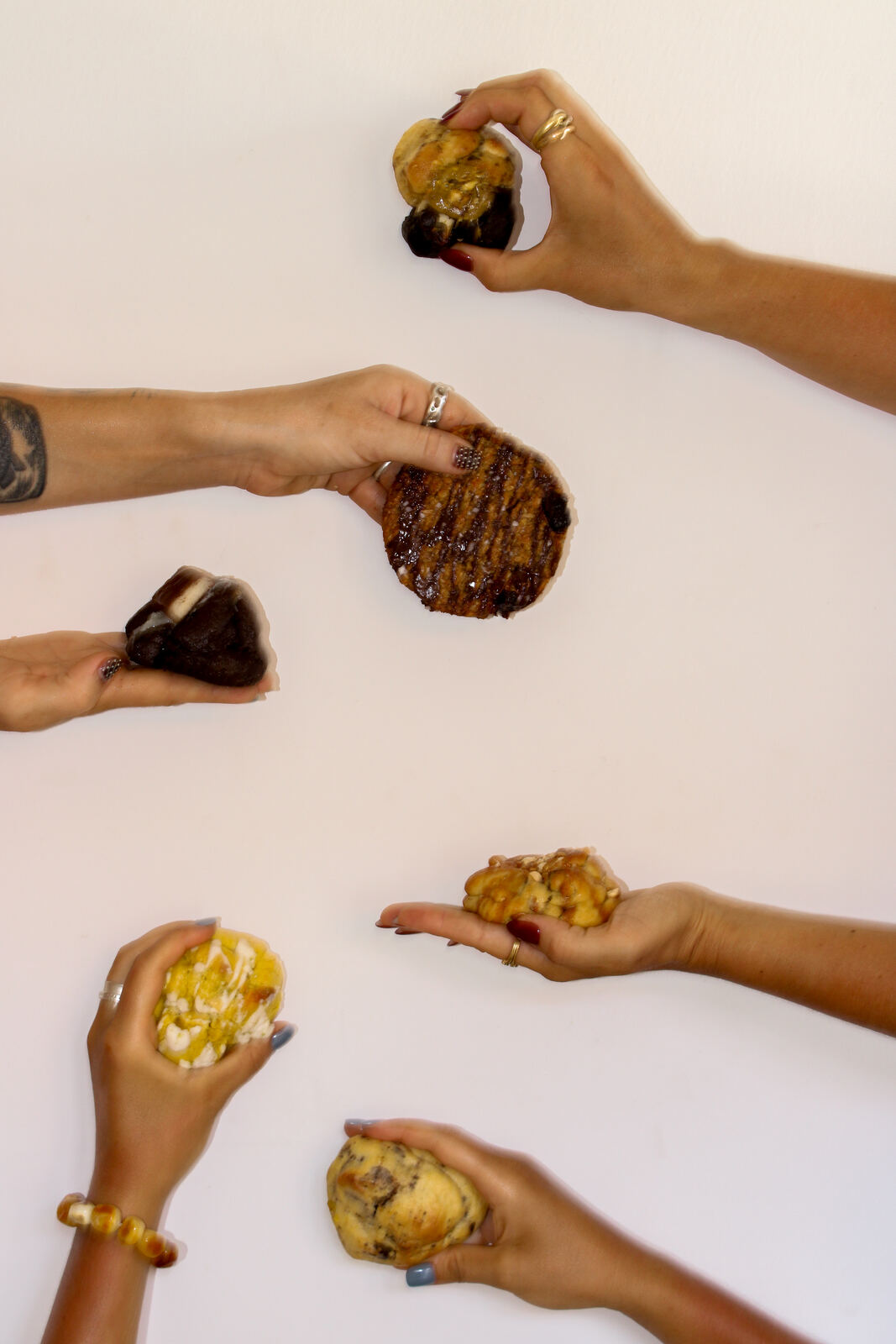 Hands holding an assortment of Kookie flavours