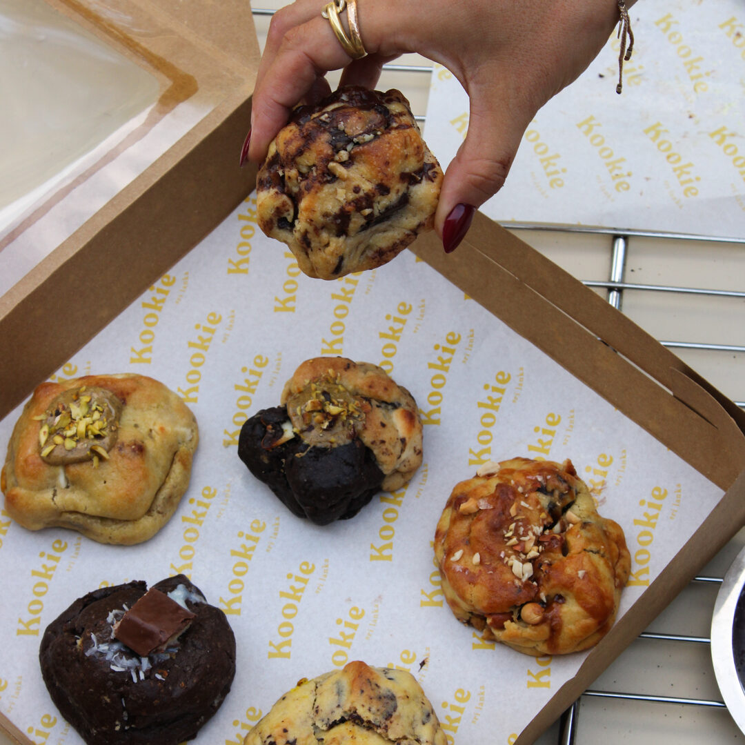 Picking a cookie from a box of assorted Kookie flavours